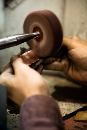 Hand polishing a piece at the wheel